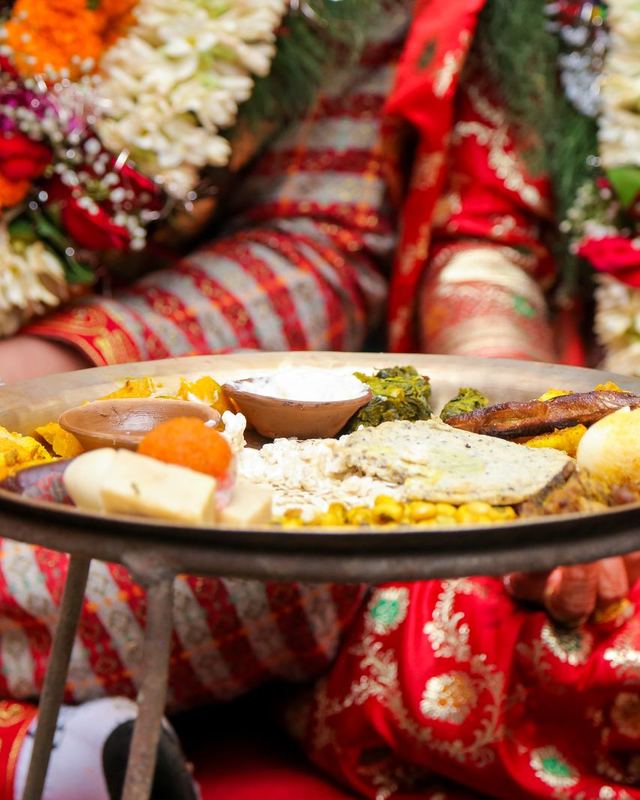 A bride holding a festive thali at a wedding