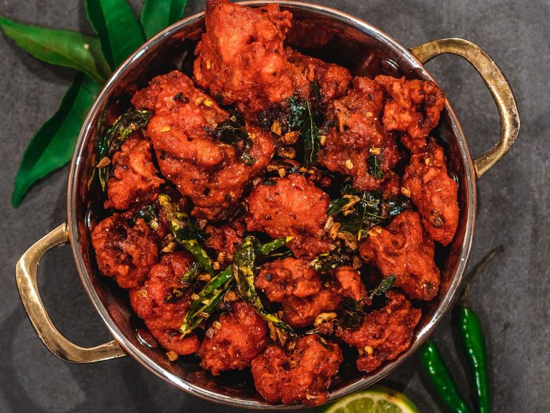 Fried chicken pieces with green chillies and lime