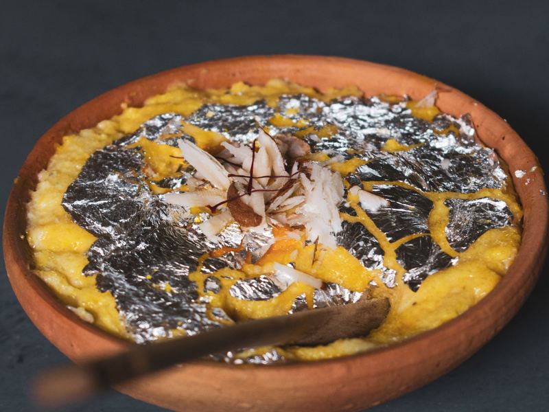 Firni in a clay bowl with almonds